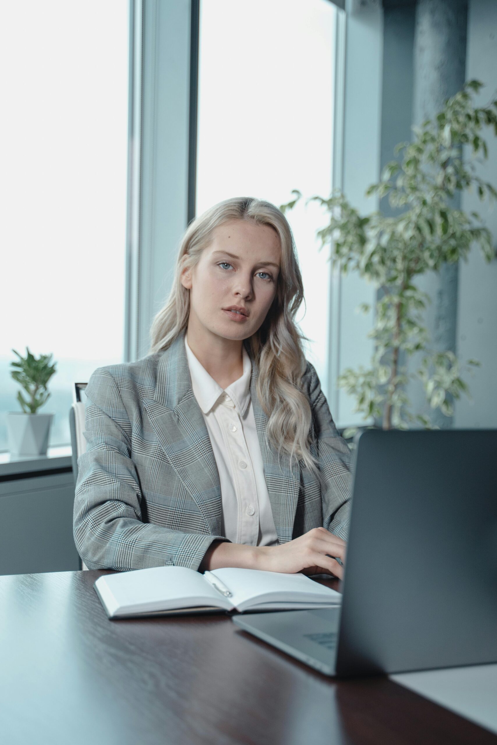 Portrait of a confident businesswoman working on her laptop in a modern office setting.